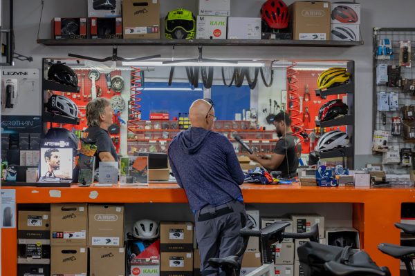 Mannie himself with a customer at Mannie's Bike Mecca store counter.